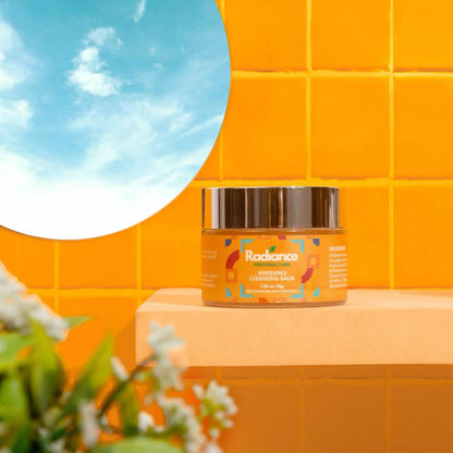 Jar of Radiance skincare product on a yellow tiled wall with a round mirror and plant.